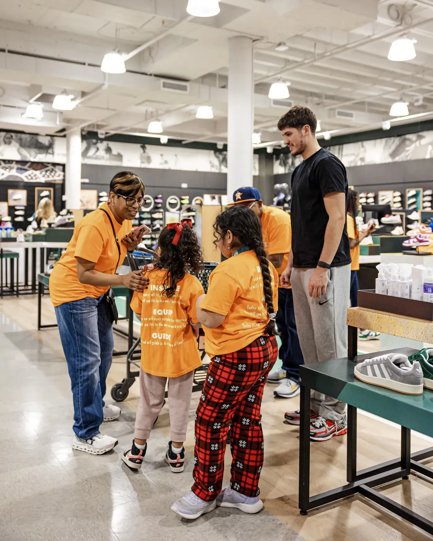 Volunteers helping children pick out new shoes at a giveaway